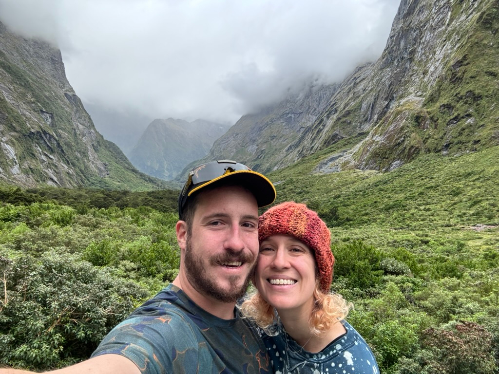 Couple in front of the grandiose views on the drive to Milford Sound, New Zealand