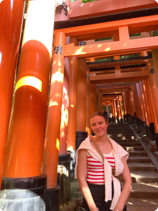 A German woman with Fushimi Inari Shrine in Kyoto, Japan in the background