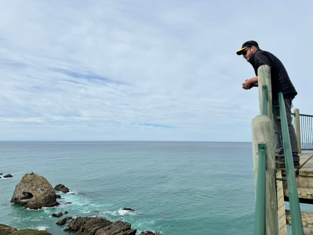 A man taking in the views from Nugget Point Lighthouse off the Southern Scenic Route in New Zealand.