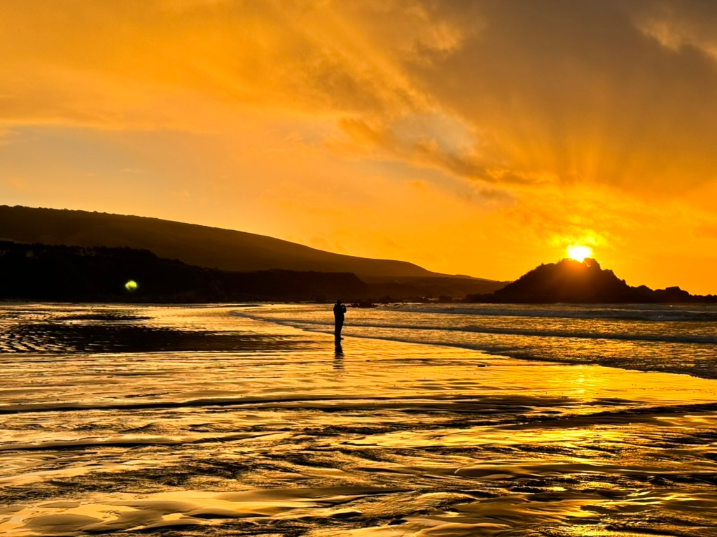 A stunning sunset at Monkey Beach freedom camping in New Zealand