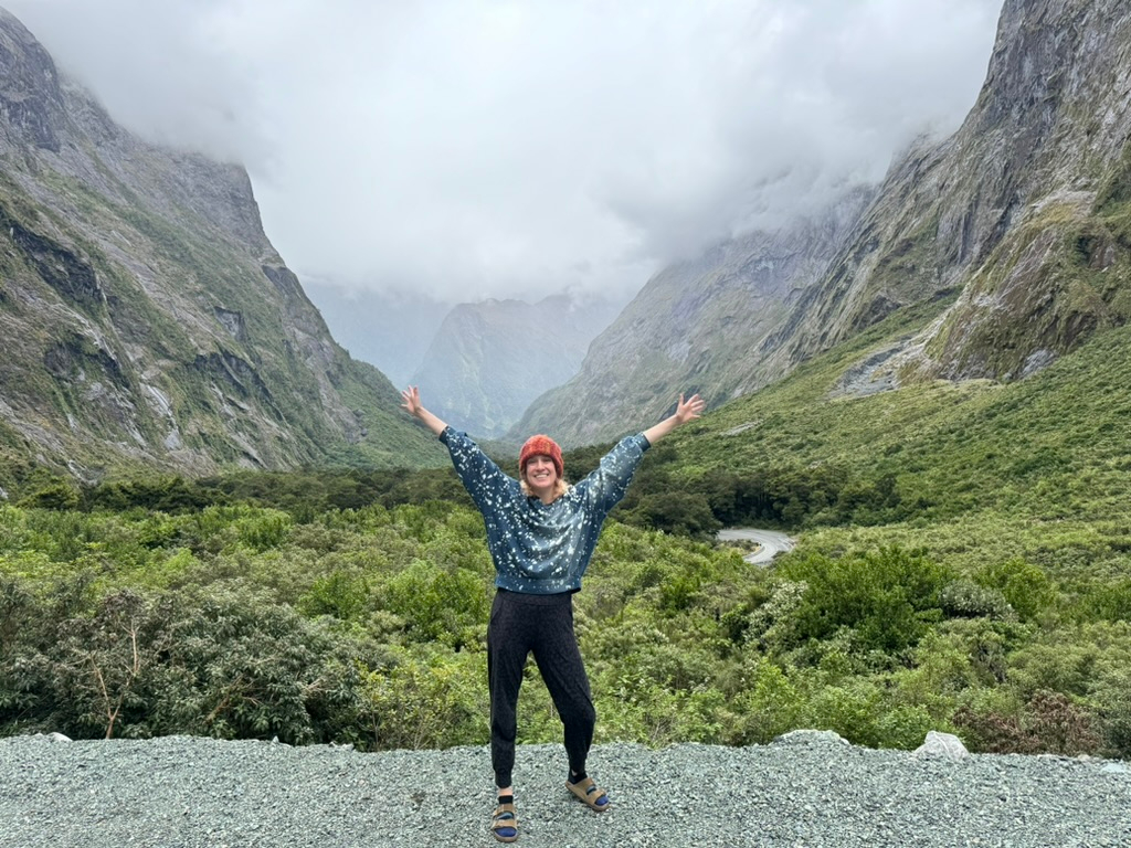 Woman in front of the grandiose views on the drive to Milford Sound, New Zealand