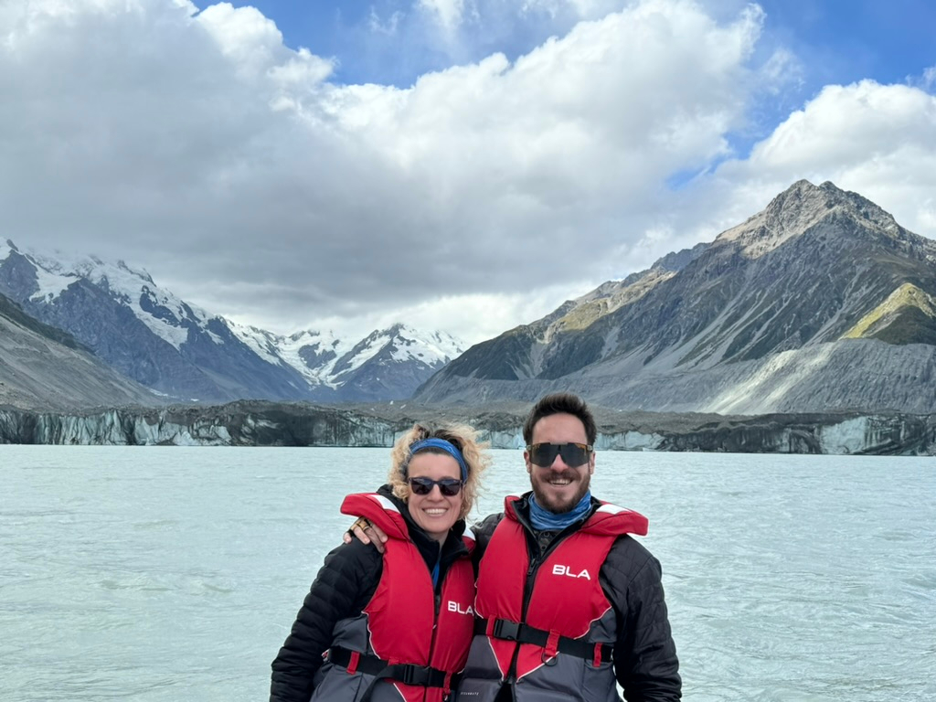 A couple with Tasman Glacier in the background in New Zealand