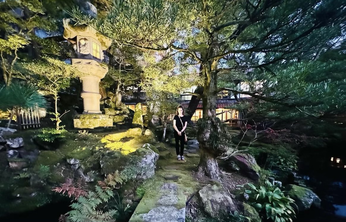 Woman in Japanese garden at Houshi Ryokan in Komatsu, Japan