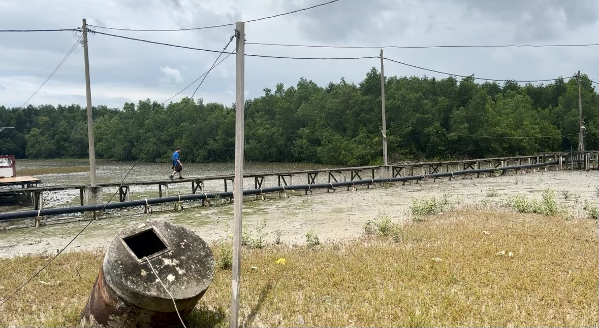 Man walking on long wooden platform on Crab Island, Malaysia