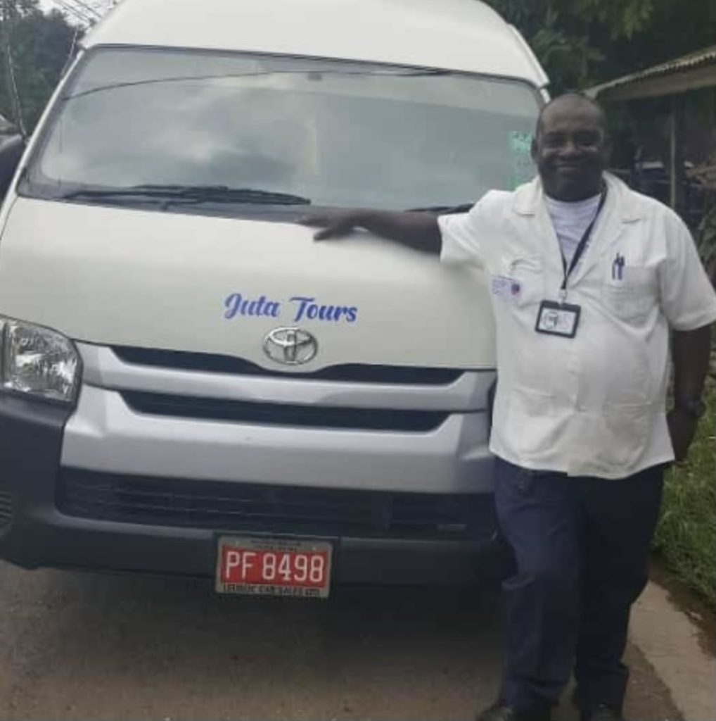 A man standing in front of a tour van in Jamaica