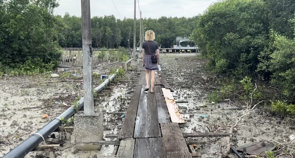 Woman walking on wooden pathway on Crab Island, Malaysia