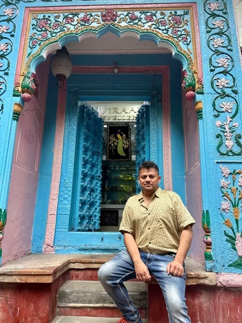 An Indian man sitting in front of an old haveli in Old Delhi