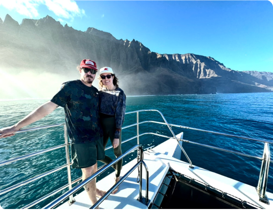 Couple on boat in front of Na Pali Coast in Kauai, Hawaii, USA