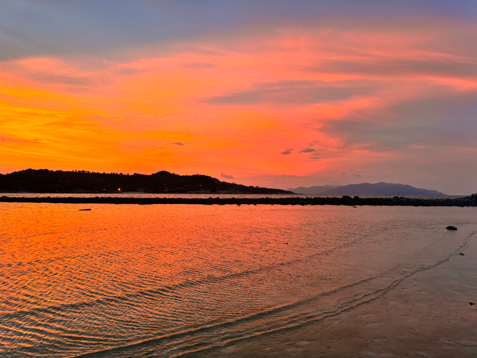 A stunning pink and orange sunset view reflecting on the ocean on Koh Samui, Thailand