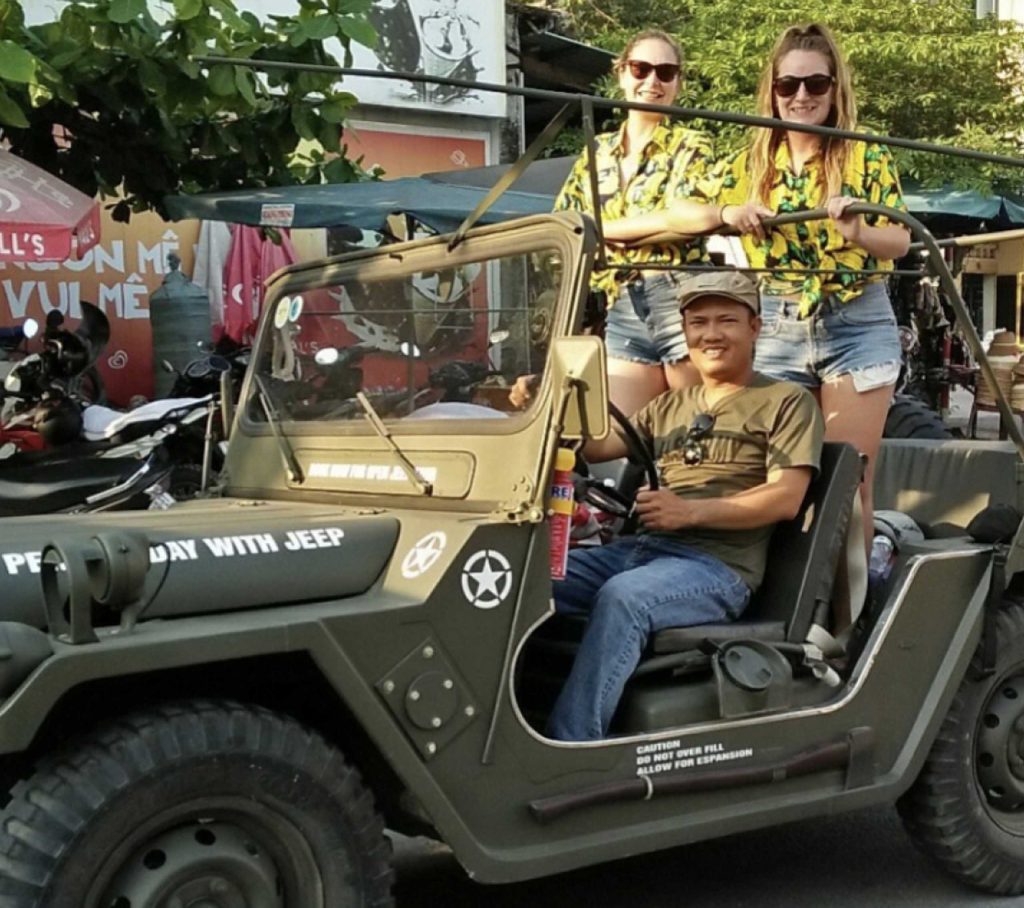 A tour guide driving a jeep with 2 women in the back in Vietnam