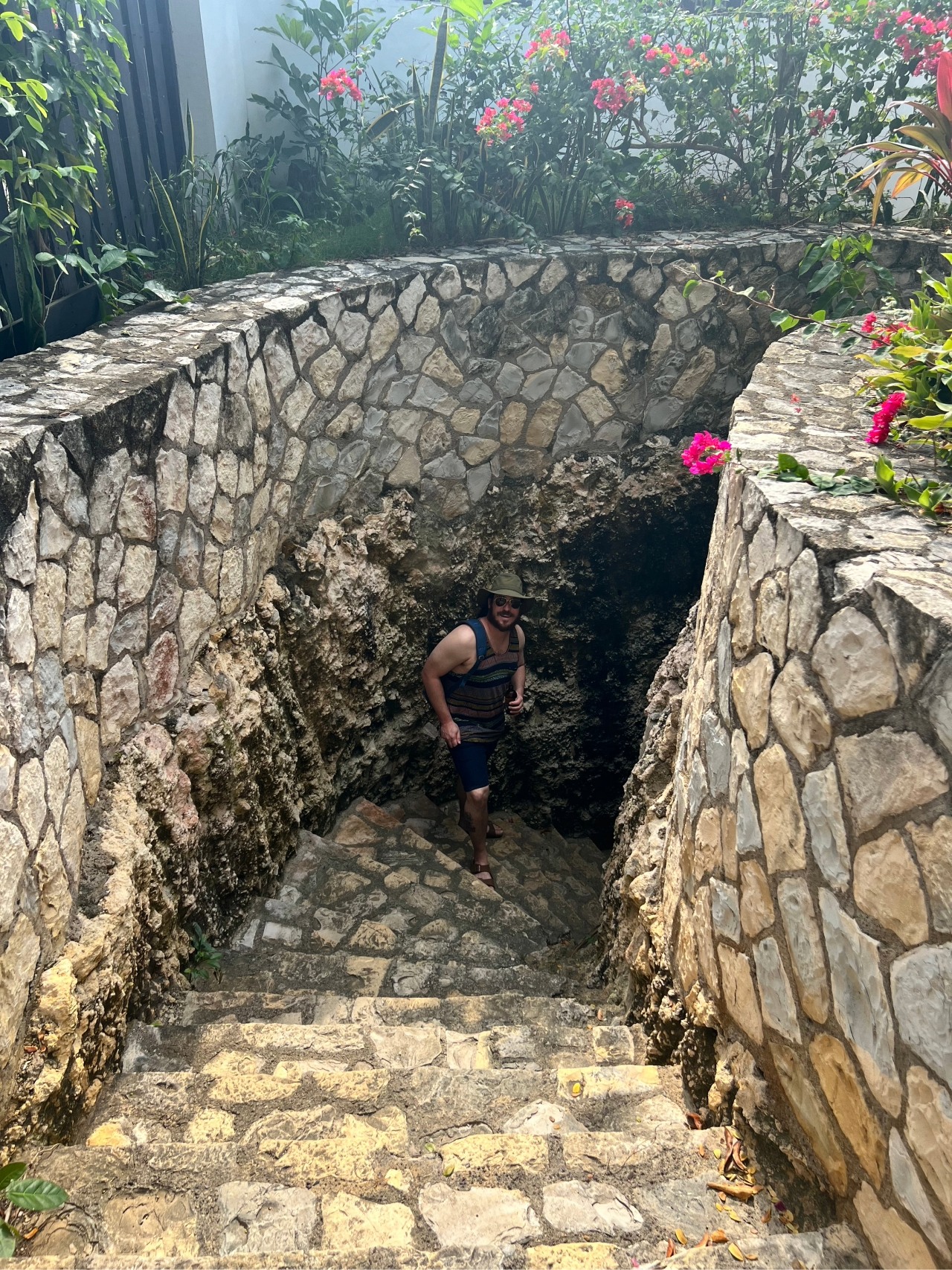 A man walking down stone steps with stone walls surrounding at Villas Sur Mer in Negril, Jamaica