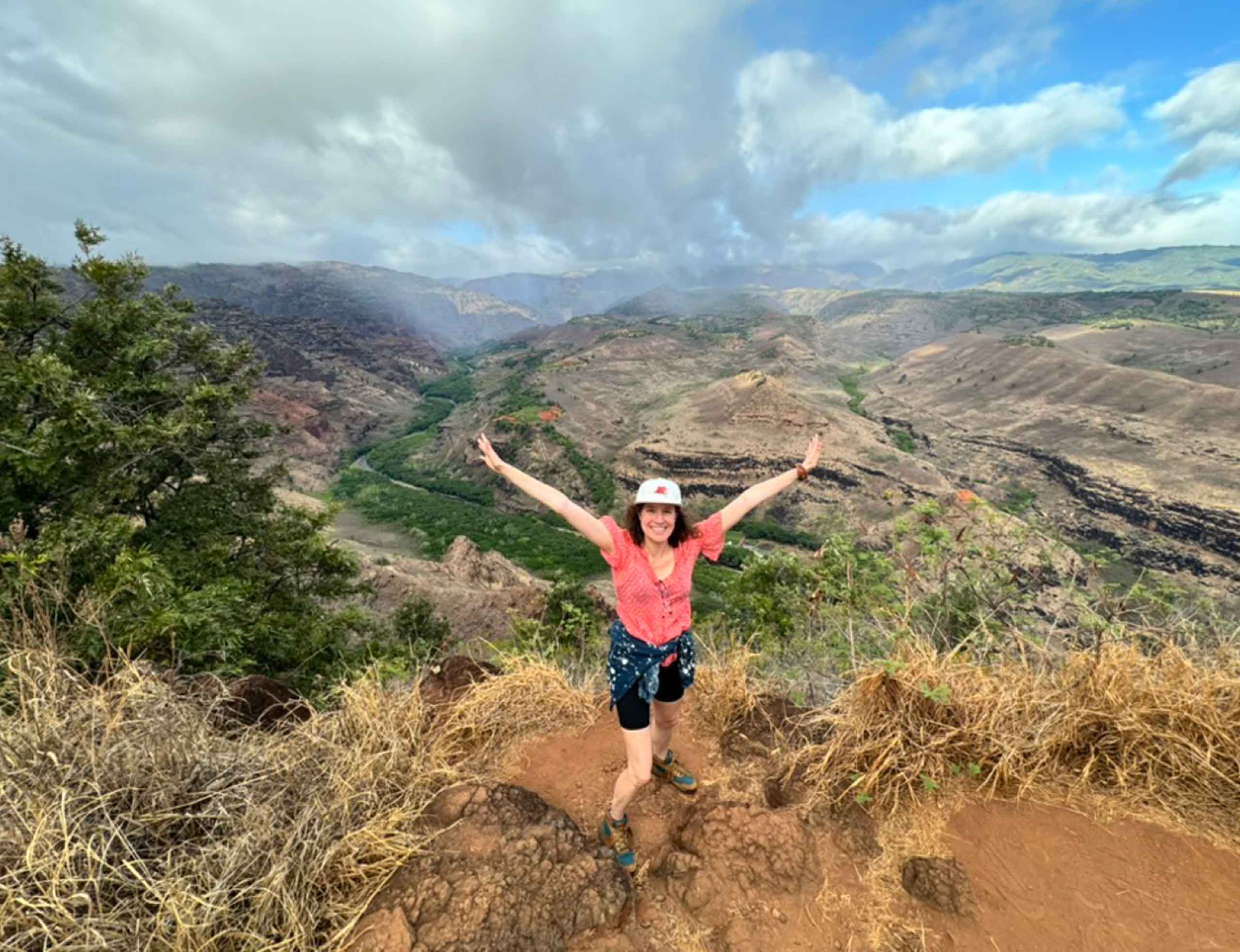 Woman in front of mountain views on the drive from Waimea to Kokee State Park in Kauai, Hawaii, USA